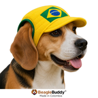 Dog wearing a yellow cap with a Brazilian flag design, branded 'BeagleBuddy'.